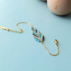 a blue beaded bracelet on a table next to a wooden ball and some beads