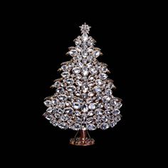 a crystal christmas tree with lots of diamonds on it's base, against a black background