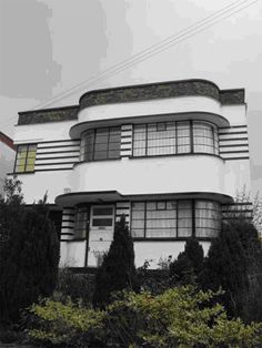 a large white house sitting on top of a lush green field