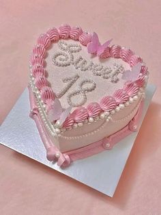 a pink heart shaped cake on top of a table