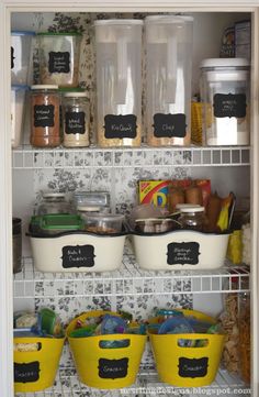 an organized pantry with chalkboard labels on the shelves and plastic bins filled with food