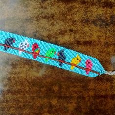 a beaded keychain with birds on it sitting on top of a table