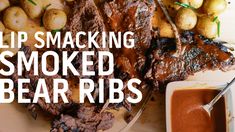 the words lip smacking smoked bear ribs on a plate with potatoes and dipping sauce