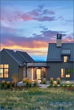 a large house with lots of windows on the front and side of it at sunset