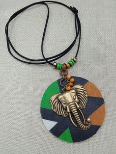 The necklace is a handmade piece. The black cord is beaded with wood and handmade hand painted beads. It is 38 inches long and goes over the head. It can be adjusted by untying the knot and adjusting the length to your specifications. The pendant includes the elephant bronze piece with wood beads and a fabric circle. It is approximately 3 inches round. If you have any questions please feel free to contact us at anytime. Adjustable Hand Painted Black Necklace, Painted Beads, Hand Painted Beads, African Necklace, African Beads, Handmade Jewelry Designs, Jewelry Handmade, Wood Beads, Jewelry Designs