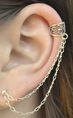 a close up of a person's ear with a chain attached to the ear