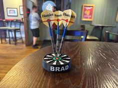 three darts with the name brad on them sitting on top of a wooden table