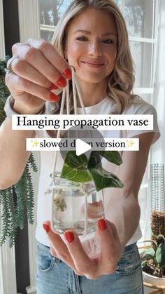 a woman holding a plant in a jar with the caption hanging propagation vase