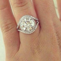 a woman's hand with a diamond ring on top of her finger and an engagement band