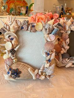 there is a frame made out of seashells on the table