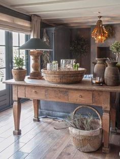 a table with two baskets on top of it and some plants in front of it