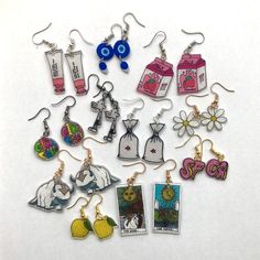 a bunch of earrings that are sitting on a table with some tags attached to them