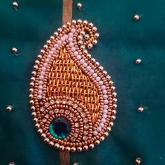 a close up of a piece of cloth with beading on it and a peacock brooch