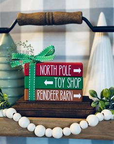 a wooden sign that says north pole toy shop reindeer barn on top of a shelf