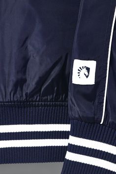 Represent TL loud and proud with the Liquid Stadium Jacket! 100% polyester raglan sleeve. White piping & front welt pockets. Felt patch at left chest & back of jacket. Stripe ribbing at collar, sleeve, bottom opening, embroidery at left pocket. Sporty Navy Nylon Track Jacket, Navy Sporty Varsity Jacket For Outdoor, Sporty Navy Varsity Jacket For Outdoor, Navy Track Jacket With Ribbed Cuffs For Streetwear, Navy Nylon Track Jacket For Streetwear, Navy Sporty Track Jacket With Pockets, Navy Sports Outerwear With Ribbed Cuffs, Navy Varsity Track Jacket With Ribbed Cuffs, Navy Sports Track Jacket With Ribbed Cuffs