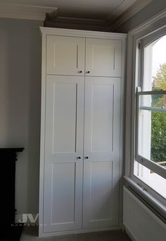 a white cabinet sitting next to a window