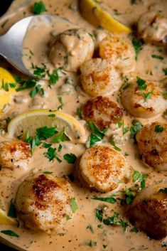 a close up of a plate of food with lemons and shrimp in sauce on the side