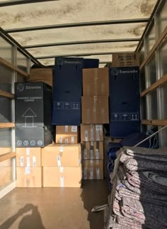 boxes are stacked up in the back of a truck with other items on the floor