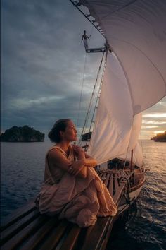 a woman sitting on the deck of a sailboat