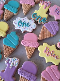 decorated ice cream cones and cookies with the words one love on them are arranged in rows