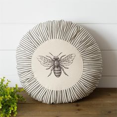 a black and white plate with a bee on it next to a potted plant