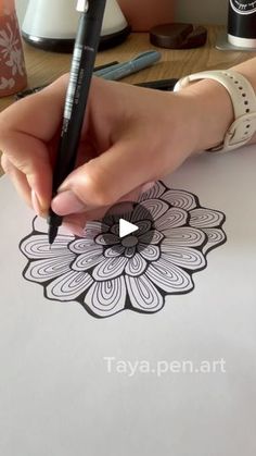 a person is drawing on paper with a pen