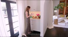 a woman standing in front of a kitchen window