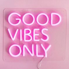 a pink neon sign that says good vibes only on the side of a wall