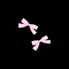 two pink bows are flying in the dark