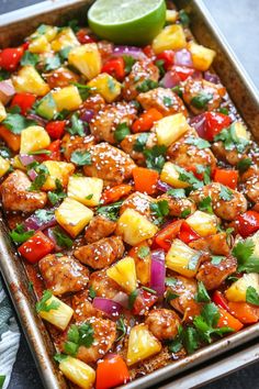 a pan filled with chicken and pineapples, cilantro, red onion, bell pepper, green onions