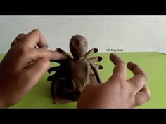 someone is making a paper sculpture of a bug on a green surface with their hands