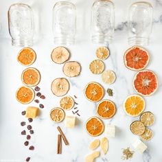 orange slices, cinnamon sticks, and other ingredients laid out on a marble counter top