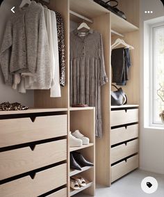 an organized closet with shoes, sweaters and other items hanging on wooden shelves in front of a window