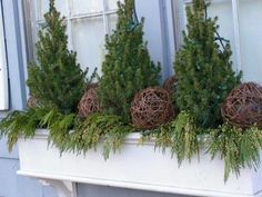 three christmas trees are sitting in a window sill with balls on top of them