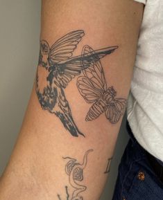 a woman's arm with a hummingbird and butterflies tattoo on the left side of her arm