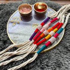 four colorful beads are on a plate next to two cups