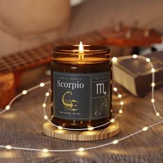 a candle sitting on top of a table next to a string of lights and a guitar