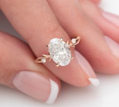 a woman's hand holding an engagement ring with a white diamond in the center