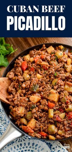 a skillet filled with meat and vegetables on top of a blue and white plate