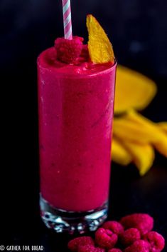 raspberry smoothie in a glass with a striped straw