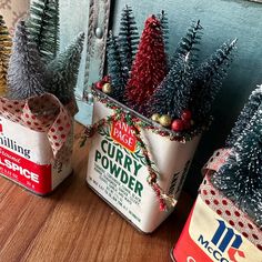 three tin cans with christmas trees in them