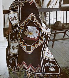 a woman is sitting on a bench wearing a blanket