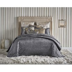 a bedroom with striped wallpaper and gray bedding