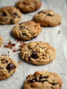 chocolate chip cookies sitting on top of a piece of wax paper