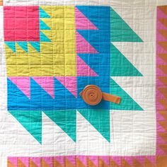 a colorful quilt with an arrow design on it