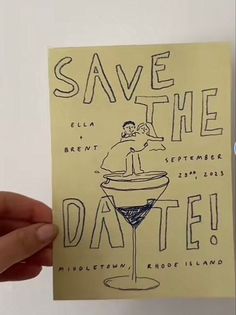 a hand holding up a card with the words save the date written in black ink