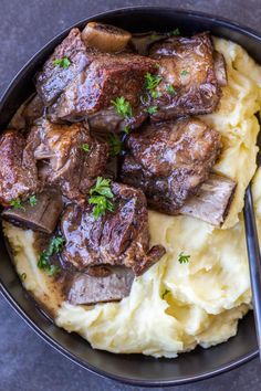 a bowl filled with meat and mashed potatoes on top of a gray countertop