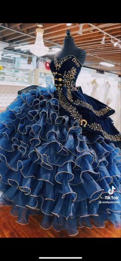 a dress that is on display in a store window, with blue and gold trimmings