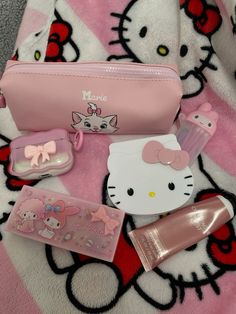 hello kitty cosmetics and accessories are laying on a blanket