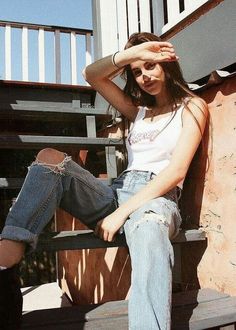 a woman sitting on top of a wooden bench